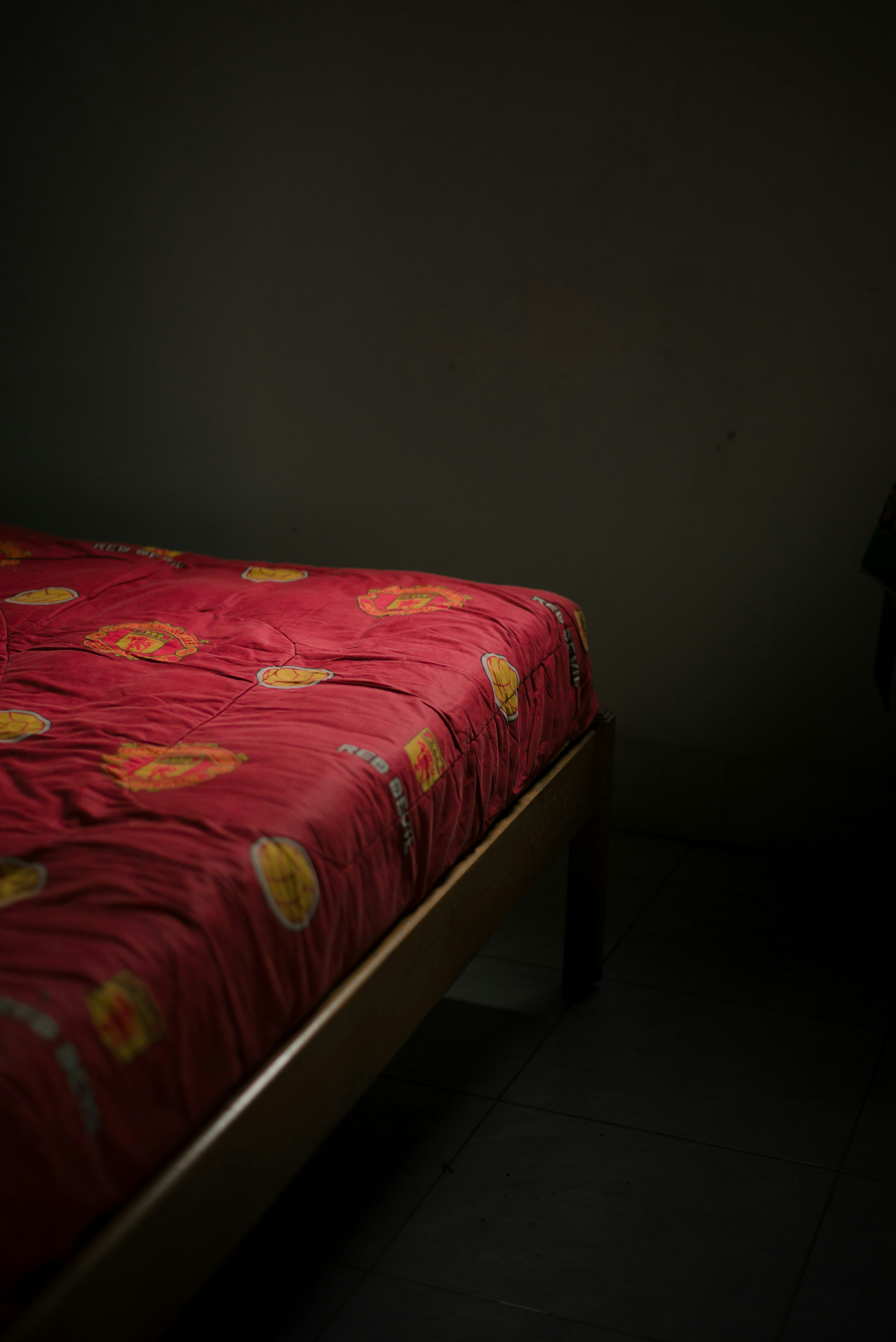 A bed with a red patterned comforter.